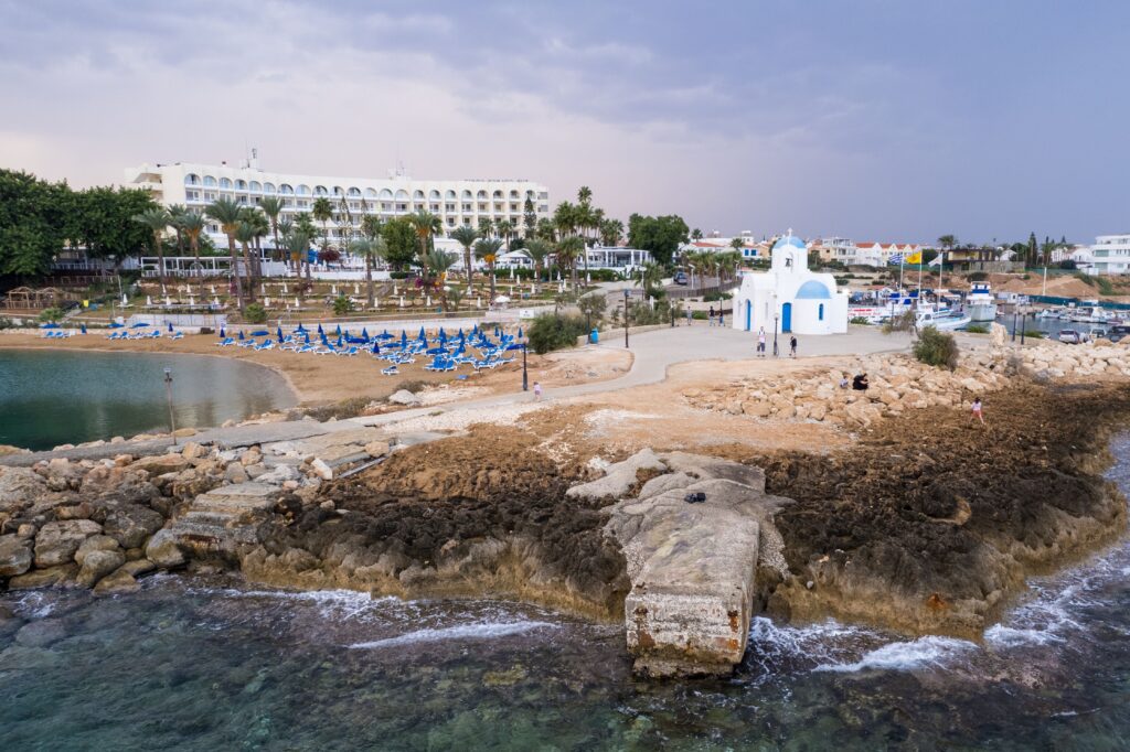 Aerial view of a church near the beach in Pernera, Cyprus, capturing the serene coastal landscape.