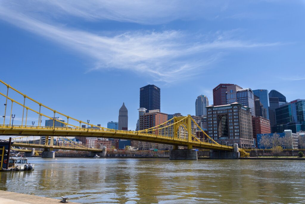 Scenic view of the Pittsburgh skyline featuring the yellow bridge on a clear day.