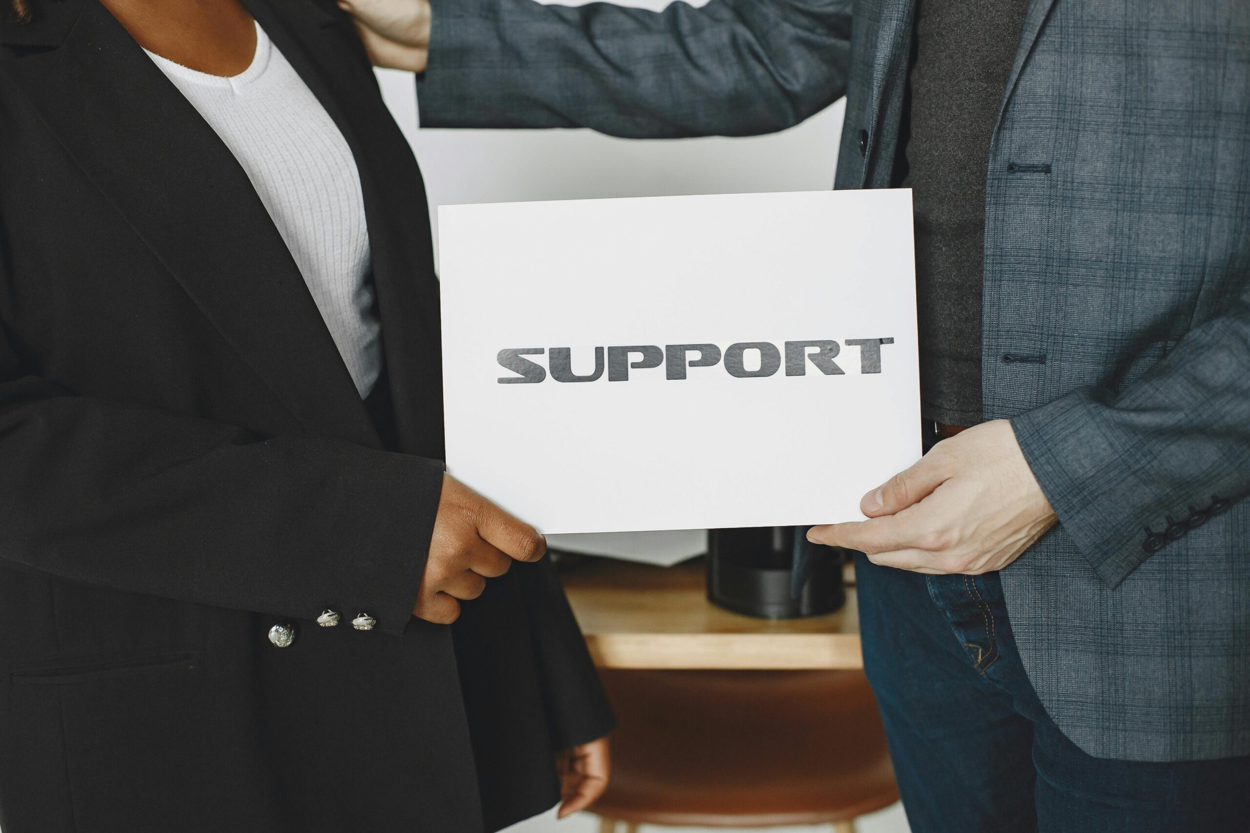 Business diversity and support concept with professionals holding a support sign.