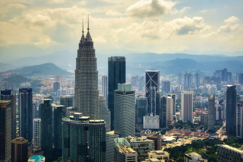 A stunning aerial view of Kuala Lumpur's skyline highlighting the iconic Petronas Towers.