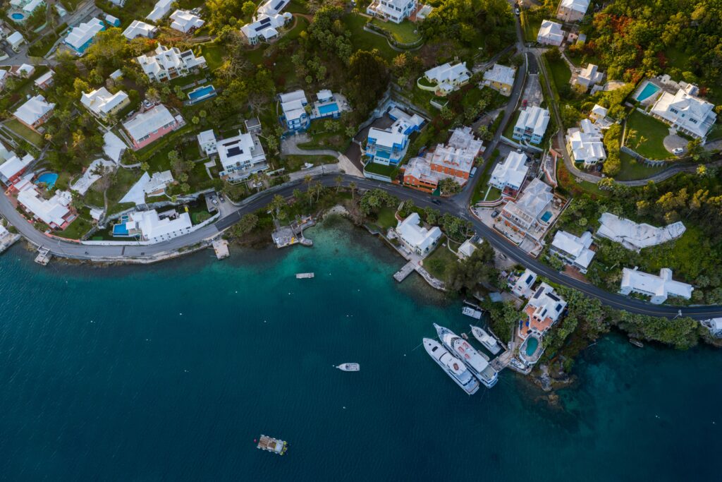 Stunning aerial photo capturing colorful coastal homes in Bermuda against the turquoise Atlantic Ocean.